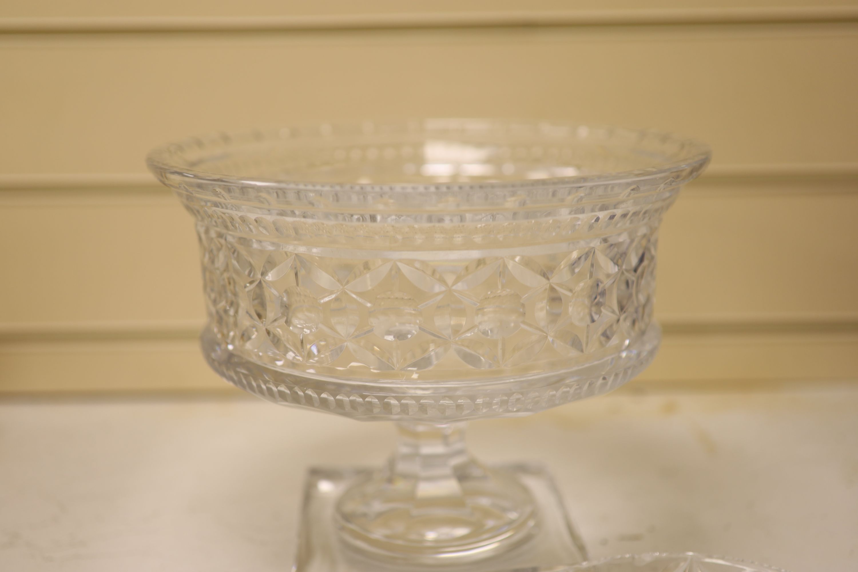 A large and heavy clear cut glass pedestal bowl, 20cm high, and two finger bowls